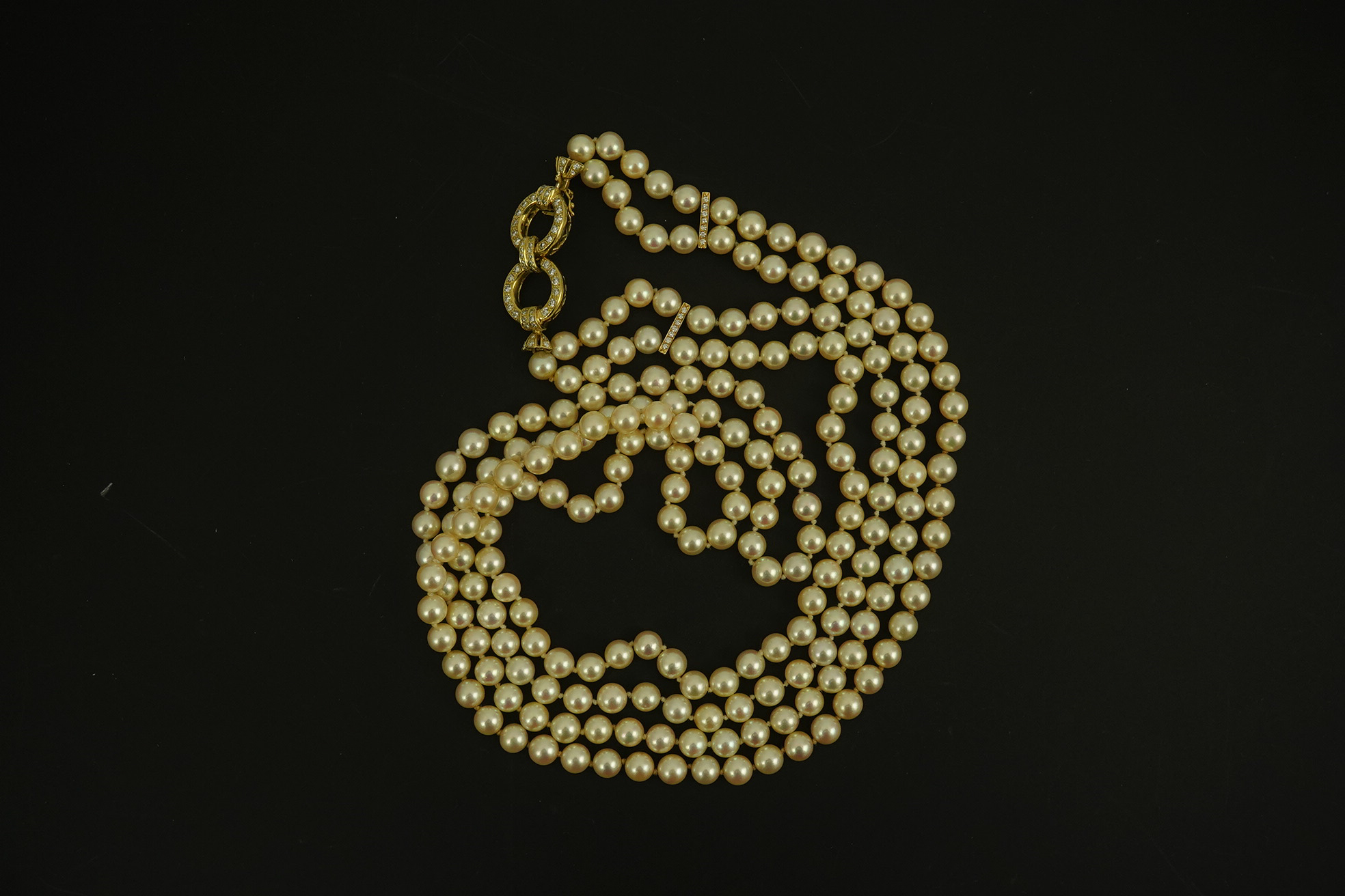 A modern double strand cultured pearl necklace, with 18k gold and diamond set twin ring clasp